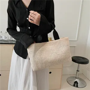 Chic beige straw tote bag with black fabric handles shown in a lifestyle home setting