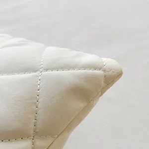 Close-up detail of white diamond quilted stitching and premium texture on fashion handbag