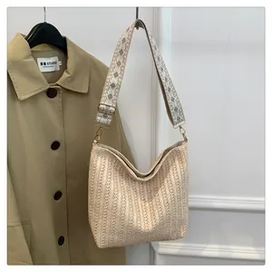 Détail du sac bandoulière tissé crème avec sangle à motifs et boucles dorées
