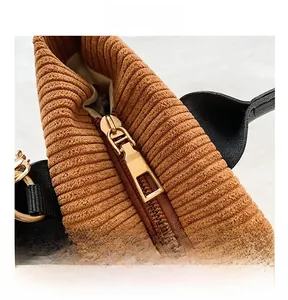 Close-up of golden metal zipper and texture on a brown corduroy tote bag detail