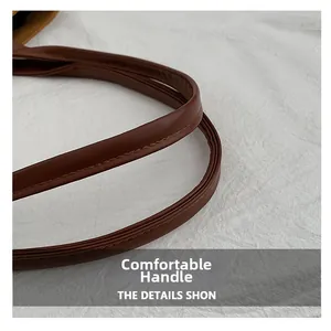 Detail of reinforced stitching and leather texture on brown suede tote bag handle