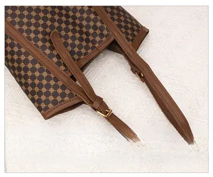 Détail de la bandoulière réglable avec boucles dorées et motif vintage sur le sac fourre-tout
