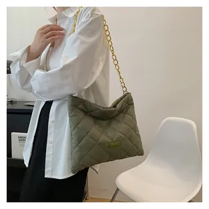 Detailed view of the grass green quilted handbag with a chunky gold chain strap