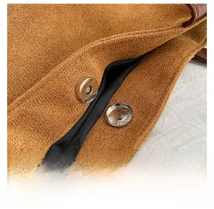 Detail of silver magnetic snap closure on a brown frosted suede tote bag with black lining
