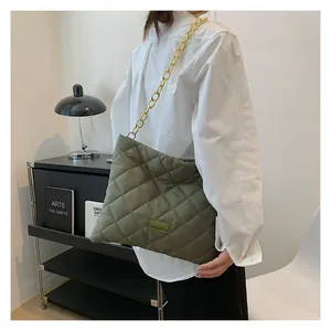 Detail of army green quilted shoulder bag with gold chain strap and fashion label