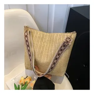Détail du sac en paille beige clair avec texture tissée et bandoulière géométrique