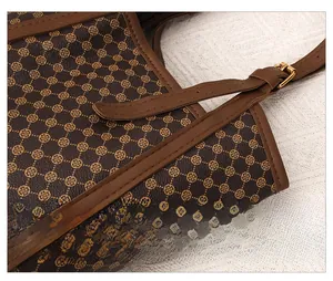 Détail du motif monogramme vintage avec garniture en cuir caramel et boucle en métal