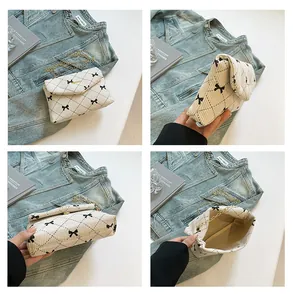 Detail view of white corduroy crossbody bag with black polka dot and bow patterns