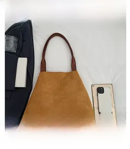 Flat lay of brown suede tote bag showing material texture and spacious laptop compartment