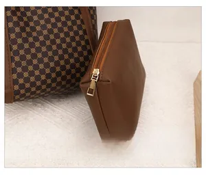 Détail d'une pochette en cuir marron avec fermeture éclair dorée et motif matelassé