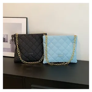 Detailed close-up of quilted chain bags in black and sky blue with gold metal straps