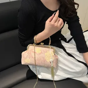 Close-up of pink floral jacquard fabric and vintage gold clasp on the Chinese shell bag