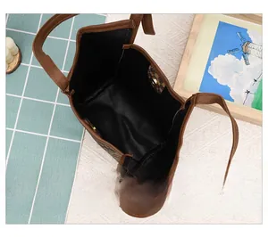 Vue de l'intérieur du sac seau marron avec fermoir magnétique et motif monogramme