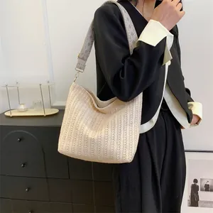 Sac bandoulière en paille tressée beige avec large sangle géométrique pour l'été