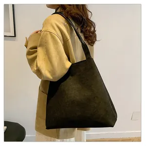Close-up of black matte faux suede tote bag showing large capacity and soft texture