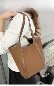 Sac seau matelassé marron avec bordure contrastée dans un centre commercial