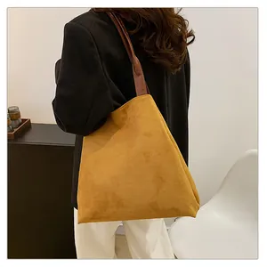Detail of minimalist ginger suede tote bag with contrast dark brown leather shoulder strap