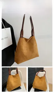 Detailed close-up of brown frosted suede tote bag with durable leather shoulder straps