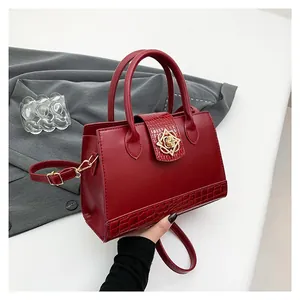 Red leather handbag with crocodile pattern details and a golden floral metal buckle