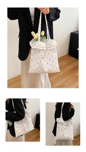 Macro detail of white polka dot tote bag with pleated texture and Fashion label