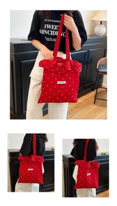 Detailed view of red polka dot tote bag featuring ruffled edges and fabric patch