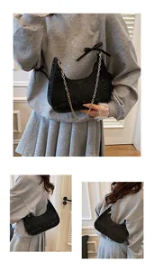 Dettaglio borsa hobo in pizzo nero con catena dorata e forma a mezzaluna