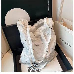 Close-up of a white floral tote bag with wrinkled texture and Fashion Bag label
