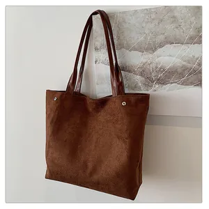 Detail of matte suede tote bag with silver side snaps and sleek shoulder strap