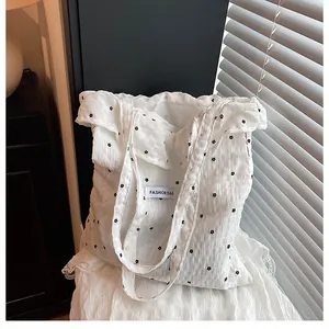 Detail of white bubble gauze tote bag with black floral pattern and Fashion Bag tag