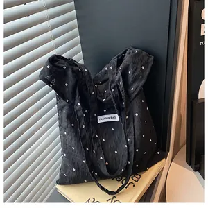 Close-up of black floral tote bag with wrinkled texture and Fashion Bag square label