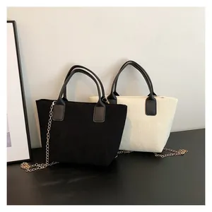 Detail of corduroy tote bags in black and cream showing soft striped texture and chain strap