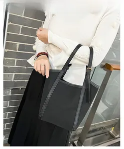 Mannequin portant un grand sac cabas noir en nylon matelassé et anses en cuir