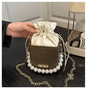 Detail der Box-Beuteltasche mit Perlengriff, Kordelzug und goldener Kettenriemen