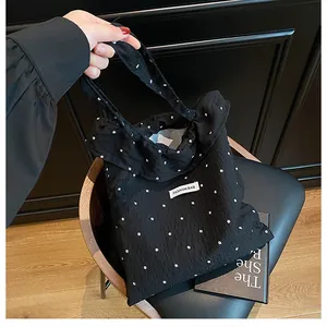 Detail of floral puff fabric tote bag with Fashion Bag label and black floral pattern