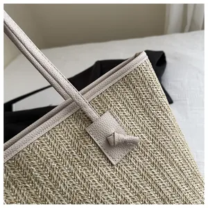 Detail of hand-woven straw tote with premium litchi grain faux leather knotted straps