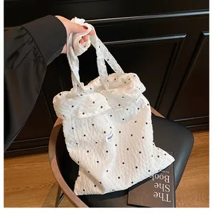 Close-up of white seersucker tote bag with black flower embroidery and Fashion label