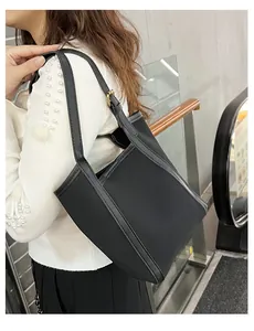 Vue latérale d'un sac seau en cuir matelassé noir porté par un mannequin en intérieur