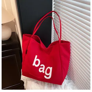 Détail du sac cabas en toile rouge avec lettrage bag blanc et poche de rangement