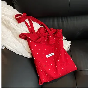 Detail view of red floral tote bag with pleated texture and Fashion Bag label on black surface