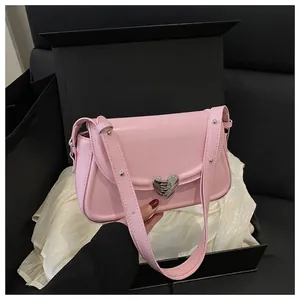 Borsa quadrata rosa con fibbia a cuore presentata in una confezione regalo di lusso