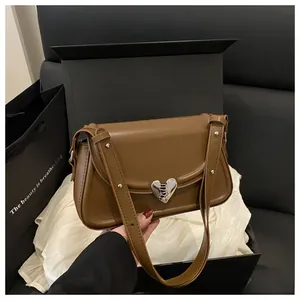 Dettaglio borsa retrò marrone con fibbia a cuore argentata in una scatola regalo chic