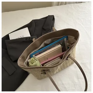 Detail of spacious straw tote bag interior showing capacity for tablet and daily items
