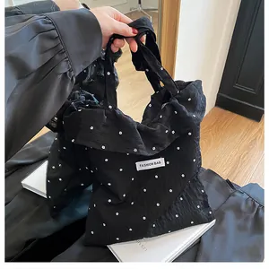 Detail of black floral ruffled tote bag with pleated texture and Fashion Bag label