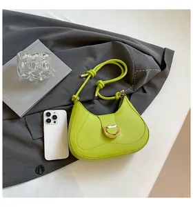 Lime green suede hobo bag with gold metal buckle shown next to a smartphone for scale