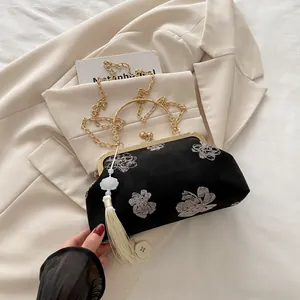 Detailed view of black velvet cheongsam bag with floral embroidery and silk tassel