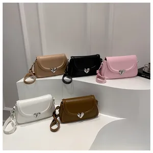 Dettaglio di borse quadrate in pelle PU colorata con chiusure a forma di cuore in metallo argento