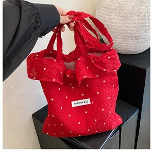 Close-up of red floral tote bag featuring a Fashion Bag label and stylish ruffled edge