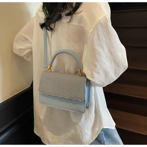 Détail du sac sous le bras bleu clair élégant avec texture tissée et bord ondulé