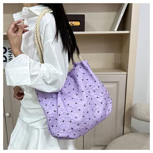 Détail du sac cabas lilas en tissu bulle avec nœuds noirs et anses en corde