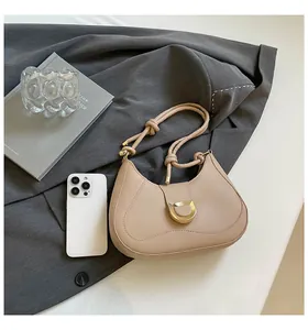 Detail of apricot moon bag featuring golden D-buckle and stylish knotted shoulder strap